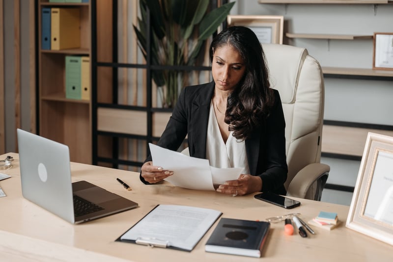 woman-sitting-in-desk-reviewing-contract